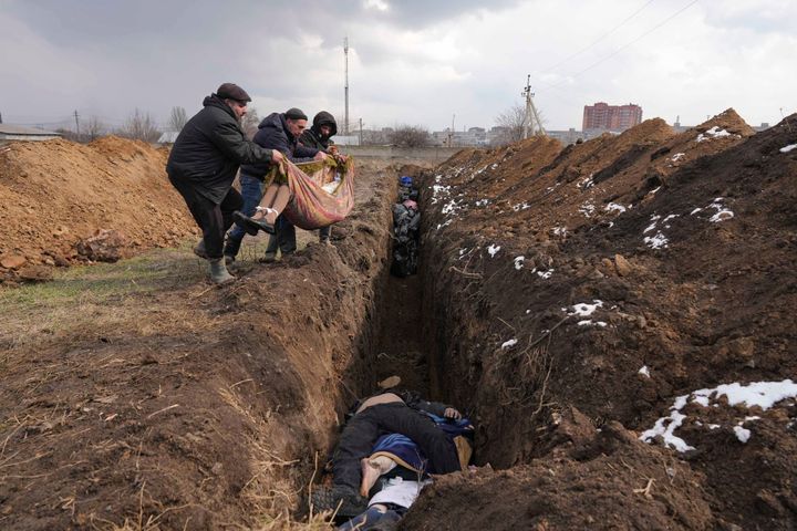 Σώματα νεκρών τοποθετούνται σε ομαδικό τάφο στα περίχωρα της Μαριούπολης, την Τετάρτη 9 Μαρτίου 2022, καθώς η πόλη βομβαρδίζεται σφοδρά από ρωσικές δυνάμεις. (AP Photo/Evgeniy Maloletka)