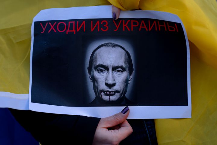 Πλακάτ διαδηλωτή με σκίτσο για τον Βλαντιμιρ Πούτιν, σε πορεία διαμαρτυρίας έξω από την ρωσική πρεσβεία στο Τελ Αβίβ του Ισραήλ. 24 Φεβρουαρίου 2022. Sign in Russian reads "get out of Ukraine". (AP Photo/Oded Balilty)