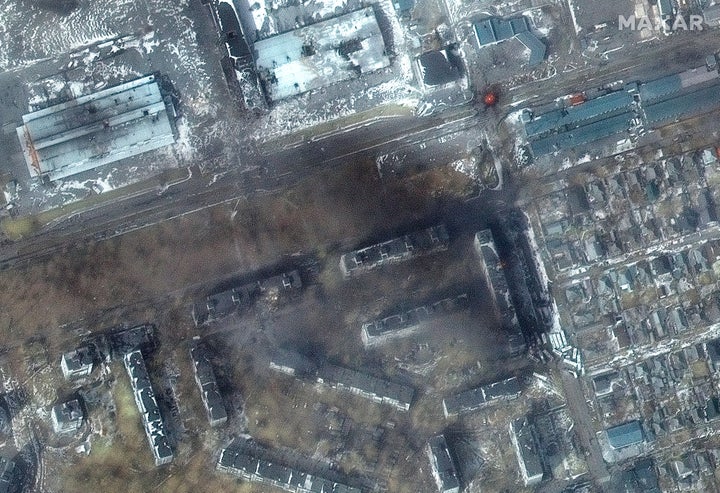 This multispectral satellite image provided by Maxar Technologies shows apartment buildings and fires in the Zhovteneyvi district of Mariupol on March 12.