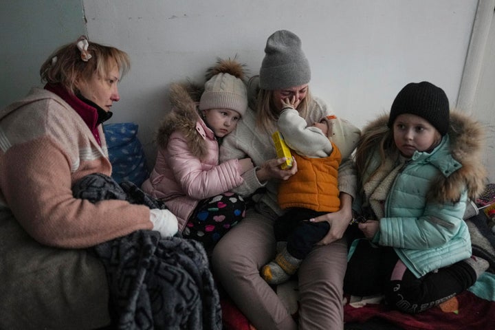 Women and children sit on the floor of a corridor in a hospital in Mariupol, eastern Ukraine Friday, March 11, 2022. (AP Photo/Evgeniy Maloletka)