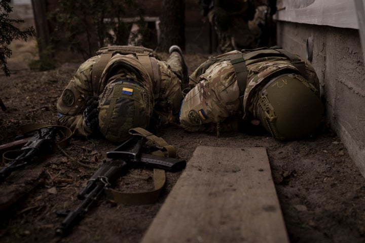 Ukrainian soldiers take cover from incoming artillery fire in Irpin, the outskirts of Kyiv, Ukraine, Sunday, March 13, 2022.
