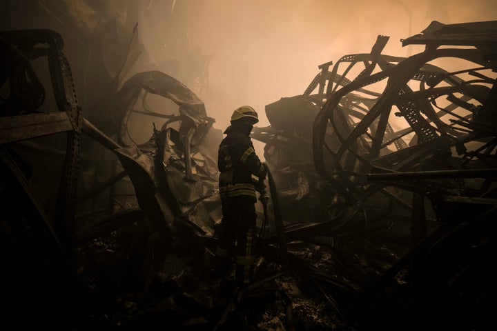 A Ukrainian firefighter drags a hose inside a large food products storage facility which was destroyed by an airstrike in the early morning hours on the outskirts of Kyiv, Ukraine, Sunday, March 13, 2022. Waves of Russian missiles pounded a military training base close to Ukraine's western border with NATO member Poland, killing 35 people, following Russian threats to target foreign weapon shipments that are helping Ukrainian fighters defend their country against Russia's grinding invasion.(AP Photo/Vadim Ghirda)