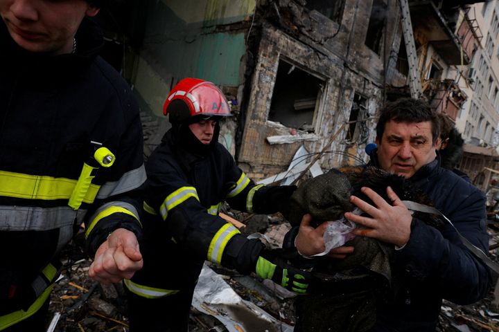 Πυροσβέστης απομακρύνει γάτα από το κτίριο που επλήγη στην συνοικία Ομπολον στο Κίεβο (14/3/2022)