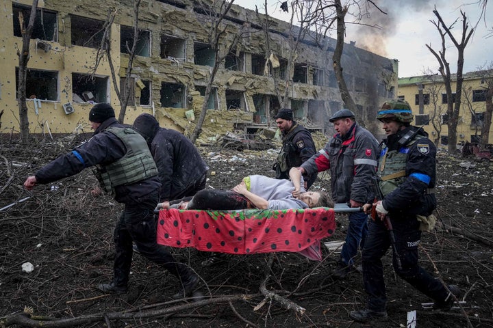 Ukrainian emergency employees and volunteers carry an injured pregnant woman from a maternity hospital that was damaged by shelling in Mariupol, Ukraine, on March 9, 2022. The woman and her baby died after Russia bombed the maternity hospital where she was meant to give birth.