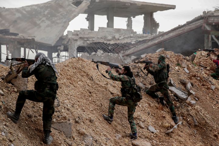 Soldados sirios empuñando sus armas en el frente contra los rebeldes de Ramouseh -este de Alepo-, en diciembre de 2016.