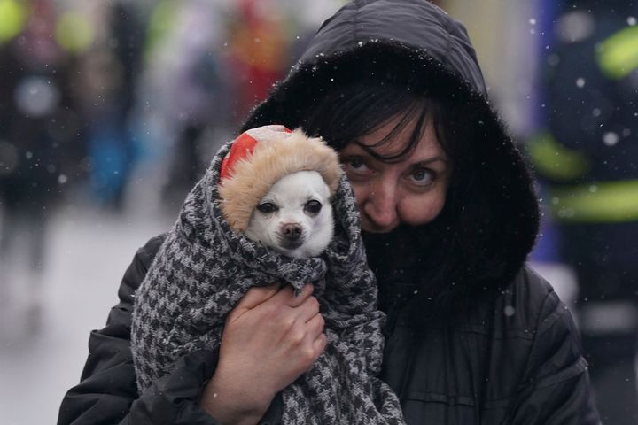 A woman carries her dog across the border from Ukraine to Siret, Romania, Wednesday, March 2, 2022, amid Russia´s invasion of Ukraine. (AP Photo/Fernando Llano)