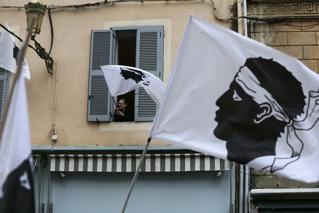 Une femme agite depuis sa fenêtre un drapeau corse le 13 mars 2022, lors d'un rassemblement de...