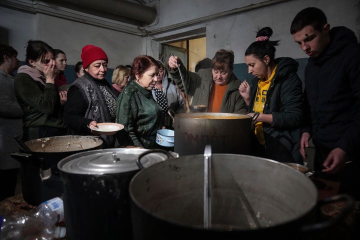 People queue to receive hot food in a improvised bomb shelter in Mariupol, Ukraine, on March 7, 2022. 