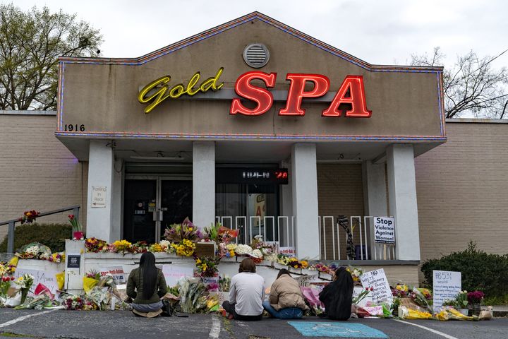 People bring flowers to the memorial site set up outside of The Gold Spa on March 19, 2021, in Atlanta, Georgia.