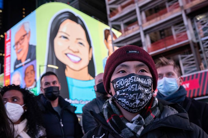 A person wearing a face mask reading, "Stop Asian Hate," attends a candlelight vigil in honor of Michelle Alyssa Go, a victim of a subway attack several days earlier, Tuesday, Jan. 18, 2022, in New York's Times Square.