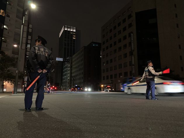 停電した交差点で手信号で交通整理する警察官ら＝3月17日未明、東京都港区