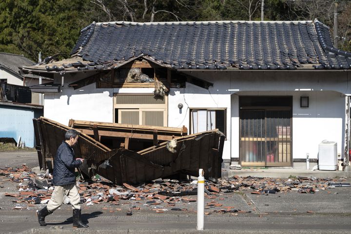 Sushi maker Akio Hanzawa walks in front of his damaged restaurant in the city of Shiroishi in Japan on March 17, 2022.