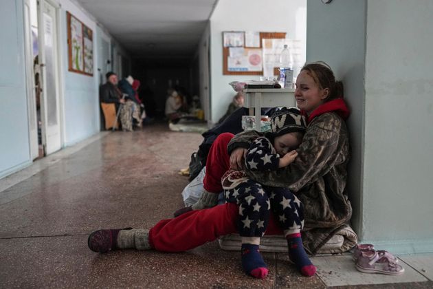 Anastasia Erashova cries as she hugs her child in a corridor of a hospital in Mariupol, Ukraine on Friday,...