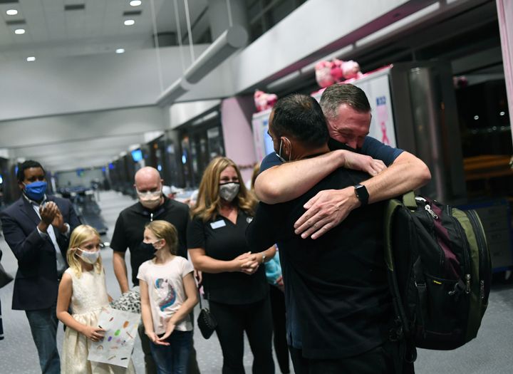Scott Henke (right) who served in the U.S. Army, hugs Afghan interpreter Ahmad Siddiqi after he and his family arrived at Denver International Airport in October 2021. Siddiqi and his family planned to resettle in a northwest Denver suburb to be near Henkel and his family.