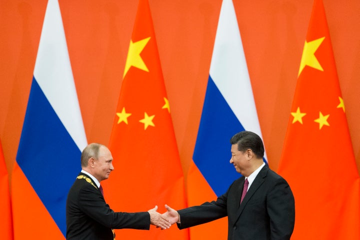 Vladimir Putin y Xi Jinping se dan la mano durante una ceremonia en Pekín, en junio de 2018.