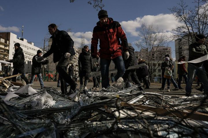 Varias parsonas caminan entre los escombros de un centro médico bombardeado en Ucrania.