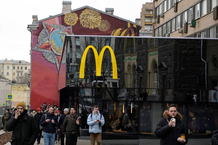 People walk in front of the McDonald's flagship restaurant at Pushkinskaya Square, the first one of the chain opened in the USSR in 1990, in central Moscow on March 13, 2022, McDonald's last day in Russia.
