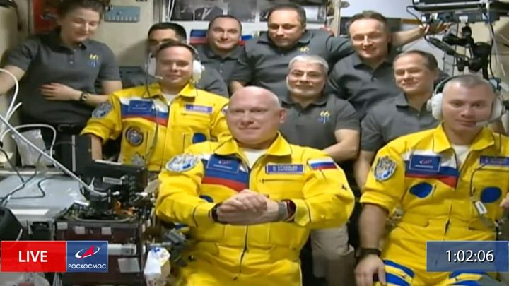 黄色に青の模様をあしらった宇宙服を着たロシアの宇宙飛行士たち（2022年3月18日）