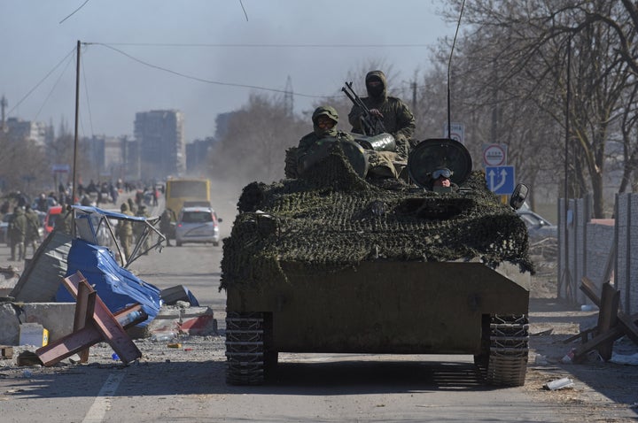 Service members of pro-Russian troops in uniforms without insignia drive an armored vehicle in the besieged southern port city of Mariupol on Saturday.