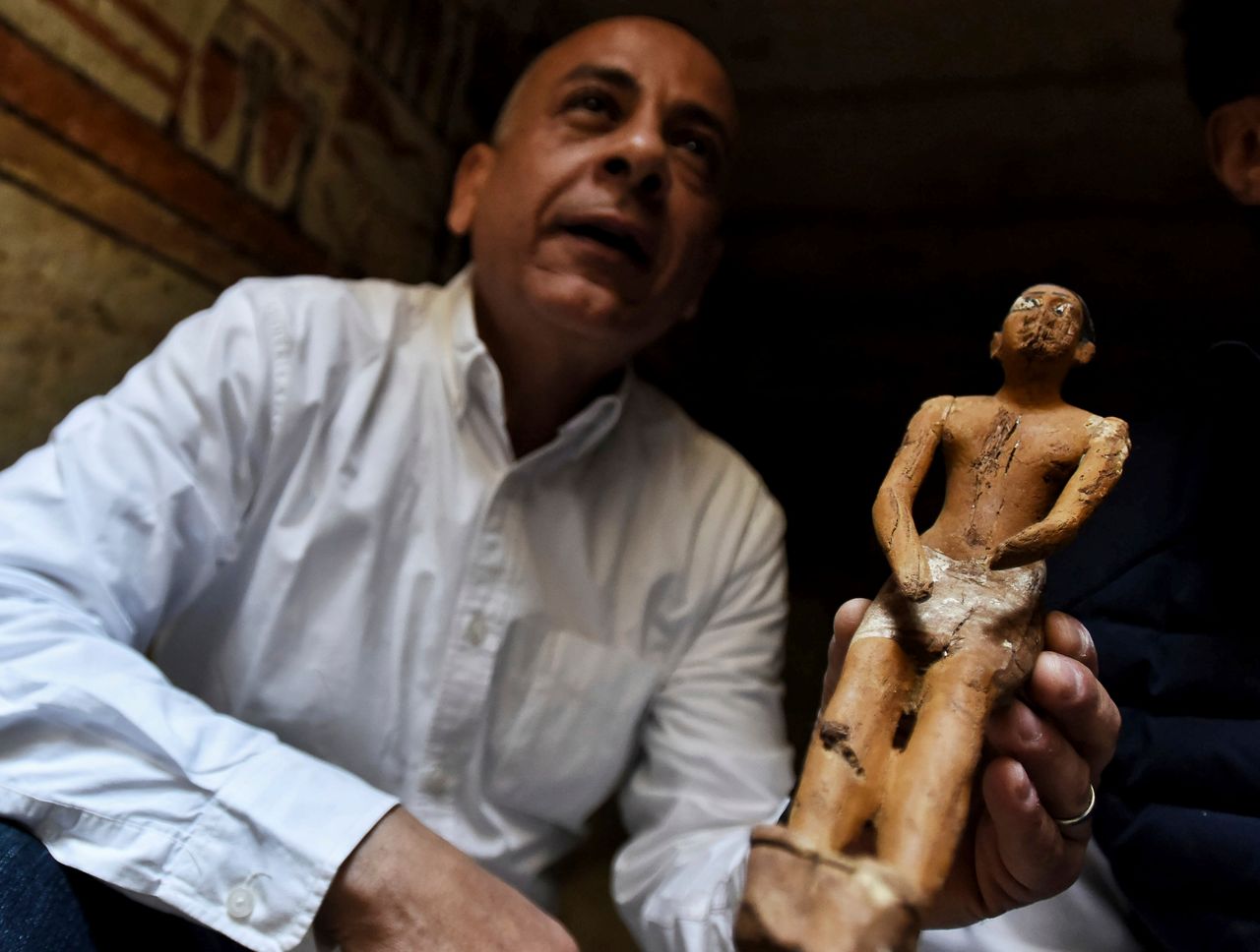 Ο Μοσταφά Ουαζιρί Γενικός Γραμματέας του Ανώτατου Συμβουλίου Αρχαιοτήτων, επιδεικνύει ένα μικρό άγαλμα σε έναν τάφο διακοσμημένο με ιερογλυφικά.
