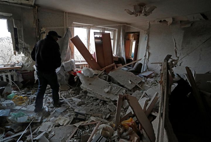 A local resident walks inside an apartment which was damaged in the besieged southern port city of Mariupol on Friday.