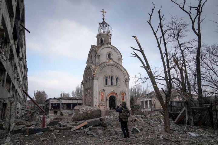 A Ukrainian serviceman takes a photograph of a damaged church after shelling in a residential district in Mariupol on March 10.