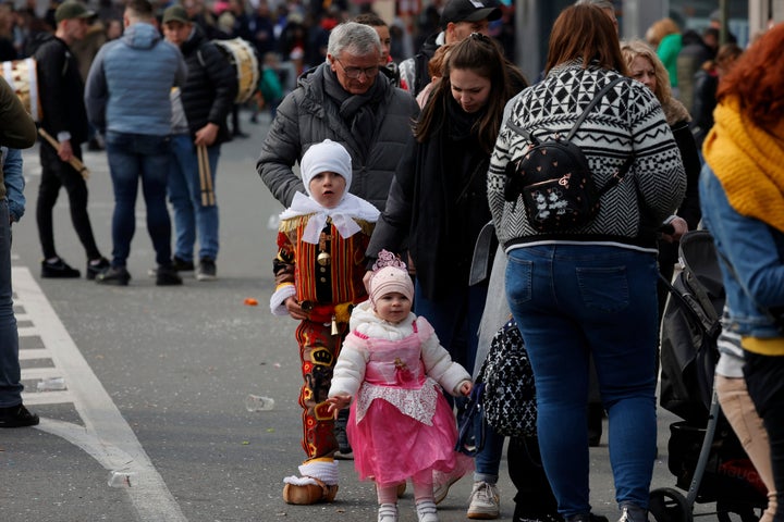 People walk home after a car slammed into people participating in a carnival in Strepy-Bracquenies, Belgium, on Sunday.