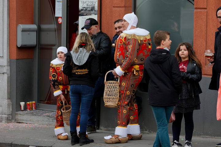 Performers and people talk on a street after Sunday's violence.