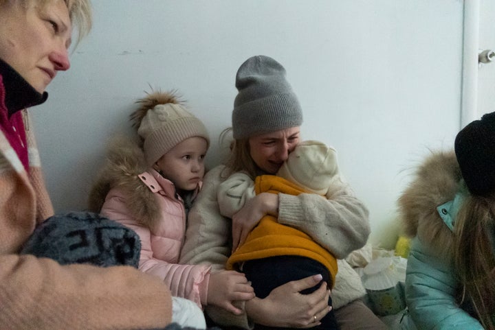 A woman whose husband was killed in the shelling cries on the floor of a corridor in a hospital in Mariupol, eastern Ukraine, on March 11, 2022.