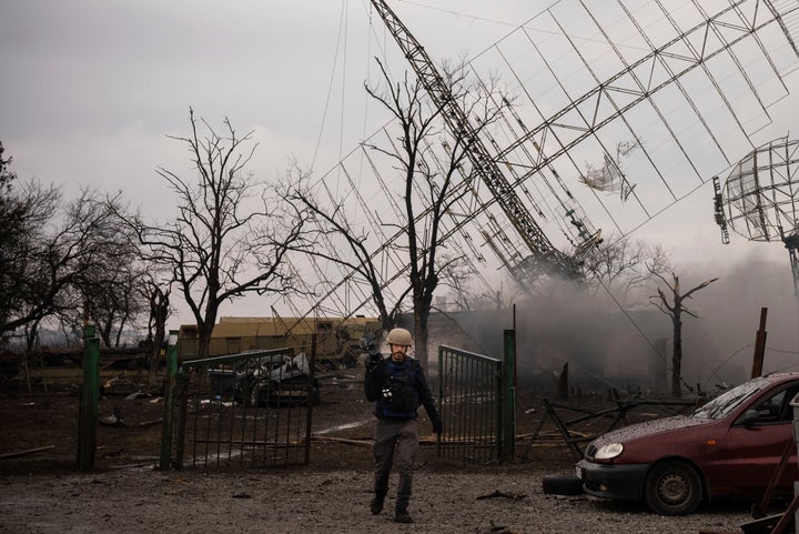 Associated Press videographer Mstyslav Chernov walks amid smoke rising from an air defense base in the aftermath of a Russian strike in Mariupol, Ukraine, on Feb. 24, 2022.