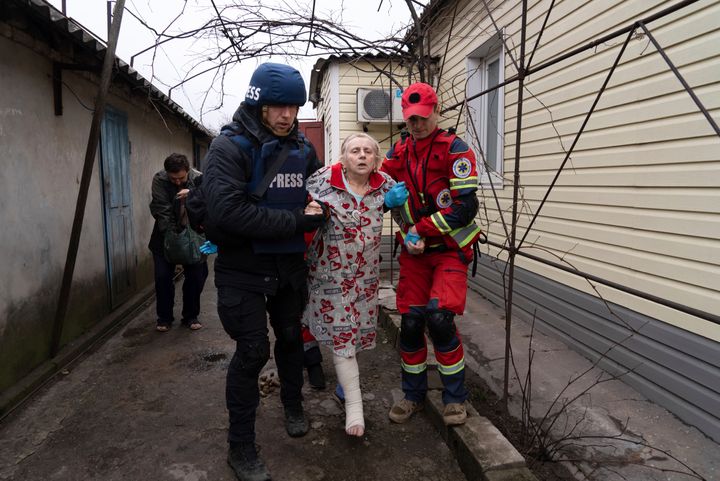 Associated Press photographer Evgeniy Maloletka helps a paramedic to transport a woman injured during shelling in Mariupol, eastern Ukraine, on March 2, 2022. (AP Photo/Mstyslav Chernov)
