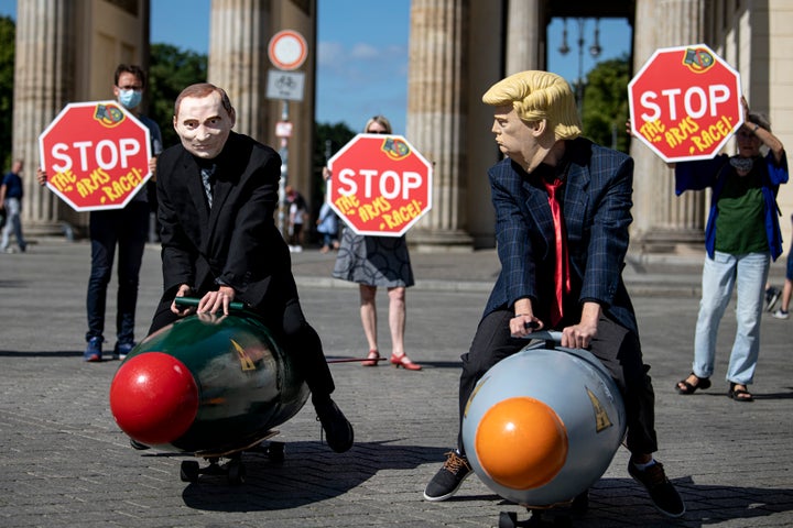 Two anti-nuclear activists dressed as then-President Donald Trump and Russian President Vladimir Putin ride models of nuclear bombs in front of Berlin's Brandenburg Gate on July 30, 2020.