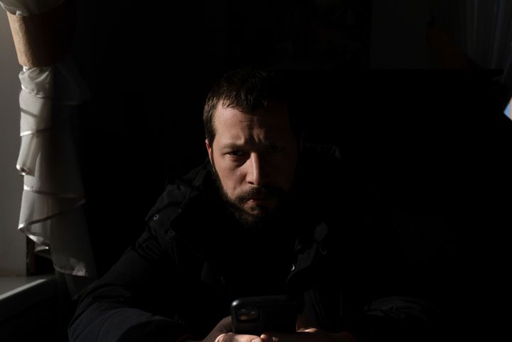 Associated Press videographer Mstyslav Chernov reads news on his phone three days before the start of Russian invasion in Volnovakha, Ukraine, Monday, Feb. 21, 2022. On the evening of Feb. 23, Chernov headed to Mariupol with colleague Evgeniy Maloletka.