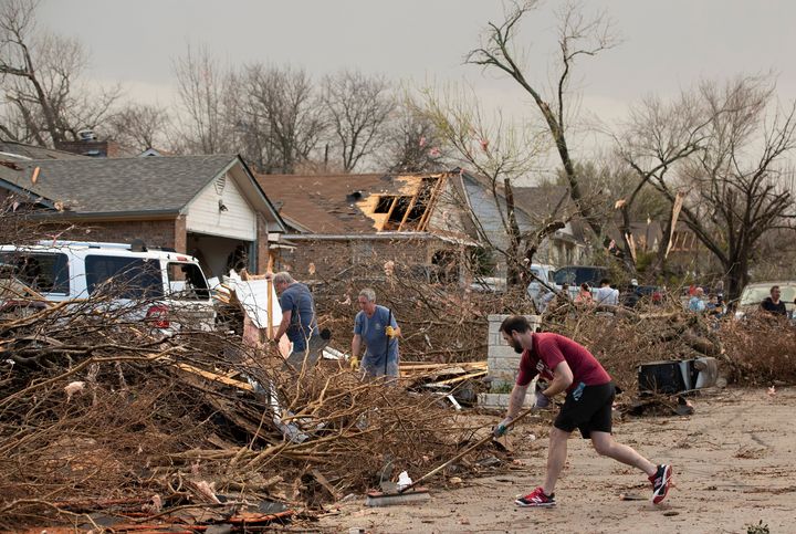 Jarrod Schneider, who lives on Oxford Drive in Round Rock, Texas, helps his neighbors clean up after a tornado heavily damaged several homes on the street on March 21, 2022. 