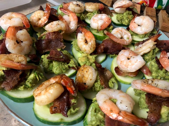 Sliced cucumbers topped with grilled shrimp, bacon and avocado