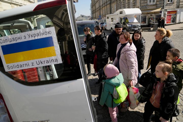 Ουκρανοί πρόσφυγες με παιδιά επιβιβάζονται σε μια πλατεία δίπλα σε σιδηροδρομικό σταθμό στο Przemysl της Πολωνίας, την Τρίτη 22 Μαρτίου 2022. (AP Photo/Sergei Grits)