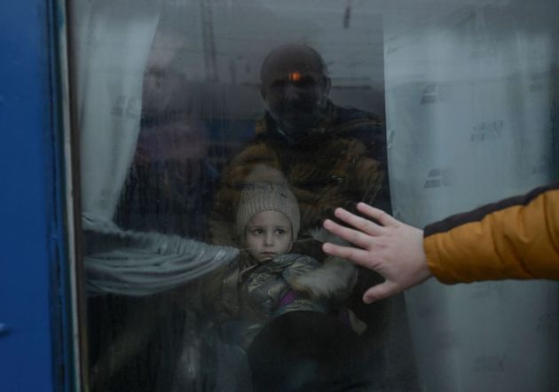 避難する列車の前で娘に別れを告げる父親が窓に手を当てる＝2022年3月7日、ウクライナ・オデッサ