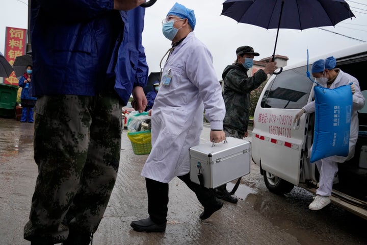 Medical workers arrive for duty near the crash site in Lu village in southwestern China's Guangxi province on Wednesday, March 23, 2022.