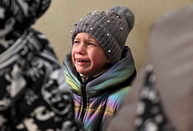 ポーランド・プシェミシルへ向かう列車に乗る準備をするおびえた少女=2022年3月19日、ウクライナ・リビウ