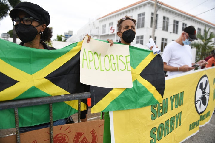 An "APOLOGISE" sign seen during the protest outside the entrance of the British High Commission.