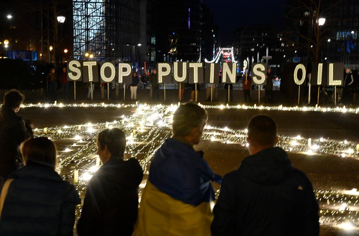 Ο κόσμος στέκεται γύρω από μια γιγαντιαία πινακίδα ειρήνης που έστησαν οι διαδηλωτές πριν από τη σύνοδο κορυφής ΕΕ και ΝΑΤΟ στις Βρυξέλλες, Τρίτη 22 Μαρτίου 2022.