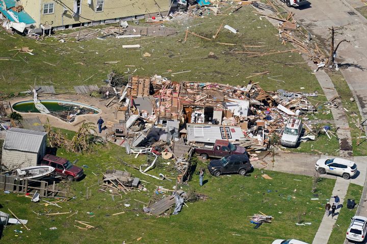 People walk amidst destruction from a tornado that struck Tuesday night in Arabi, La., Wednesday, March 23, 2022. (AP Photo/Gerald Herbert)