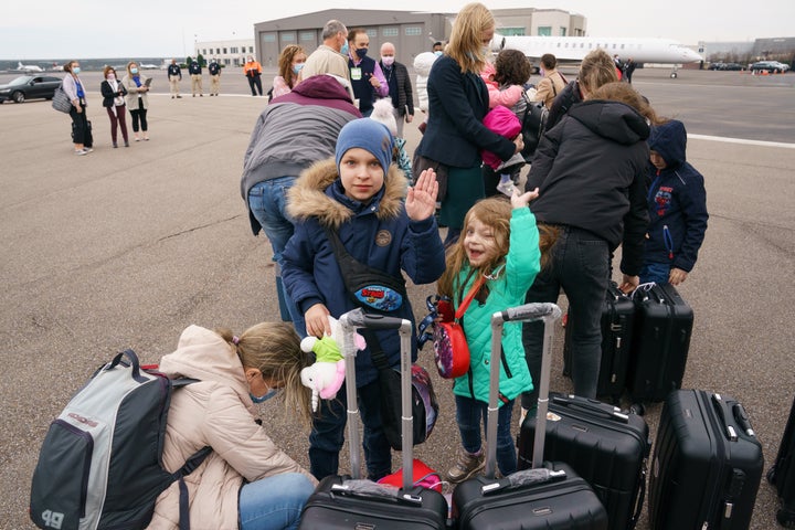 A Ukrainian pediatric cancer patient and her brother wave after arriving at Memphis International Airport with their mother, en route to St. Judge Children's Research Hospital.