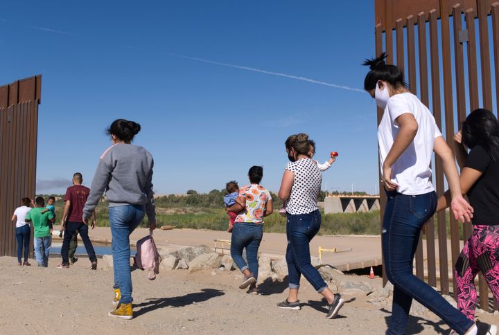 A group of Brazilian migrants make their way around a gap in the U.S.-Mexico border in Yuma, Ariz., seeking asylum in the United States.