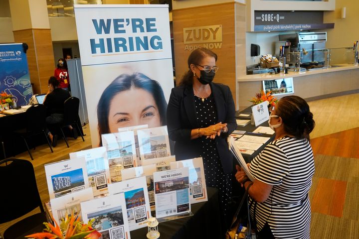 FILE - Marriott human resources recruiter Mariela Cuevas, left, talks to Lisbet Oliveros, during a job fair at Hard Rock Stadium, Friday, Sept. 3, 2021, in Miami Gardens, Fla. Fewer Americans applied for unemployment benefits last week, as layoffs continue to decline amid a strong job market rebound. Jobless claims fell by 15,000 to 214,000 for the week ending March 12, 2022 down from the previous week's 229,000, the Labor Department reported Thursday, March 17. (AP Photo/Marta Lavandier, File)