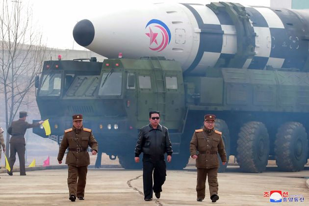 Sur cette photo publiée par le gouvernement nord-coréen, Kim Jong Un, au centre, marche devant ce qui est présenté comme un missile balistique intercontinental Hwasong-17 (ICBM), dans un lieu non divulgué en Corée du Nord, le 24 mars 2022