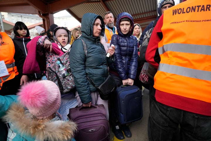 Refugees with children board a train after fleeing the war from neighboring Ukraine at a railway station in Przemysl, Poland, on March 25, 2022.