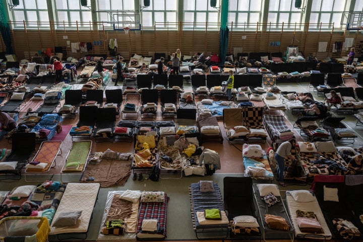 People who fled the war in Ukraine rest inside an indoor sports stadium being used as a refugee center, in the village of Medyka, a border crossing between Poland and Ukraine, on March 15, 2022.