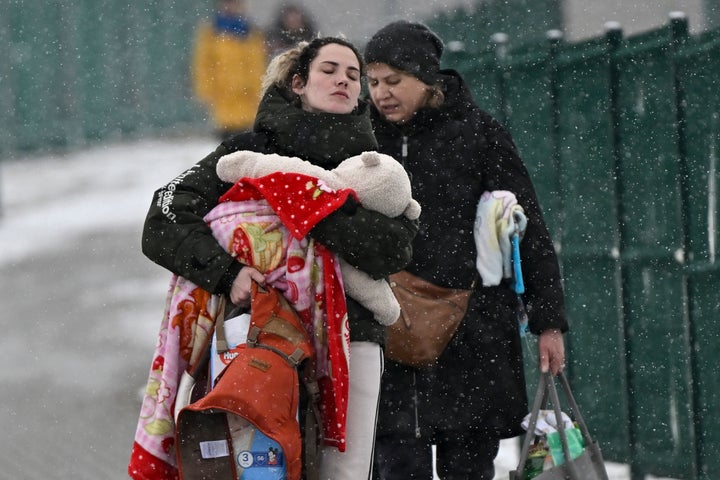 Dos mujeres y un bebé cruzan la frontera de Ucrania con Polonia, en Medyka, el 9 de marzo.