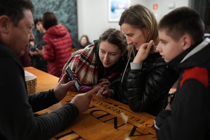 Un taxista se comunica con tres refugiados ucranianos por medio del traductor de su móvil, tras recogerlos en la frontera polaca, mientras hacen una parada en un restaurante de Burgos, el 16 de marzo. 